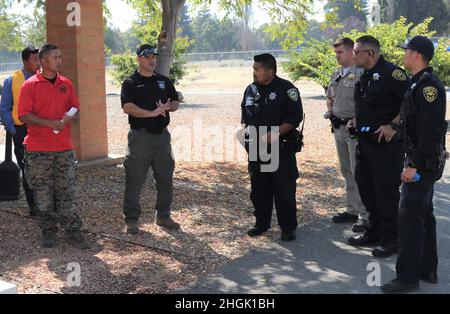 Da sinistra a destra, il vice Rueben Delapena e Sgt Kyle Benner, procuratori di esercizio dell’ufficio dello sceriffo della contea di Santa Clara, conducono un esame post-azione con i membri del team di contatto del primo responsabile dell’applicazione della legge, il funzionario della polizia Alan Corpuz del Mountain View Police Department, il California Highway Patrol Officer C. Geels, McMoore, Public Safety Officer S. Kotani, entrambi del Dipartimento di pubblica sicurezza di Sunnyvale (Legge), durante la formazione di risposta allo sparatutto attivo, presso lo Sgt. James Witowski Armed Forces Reserve Center, a Mountain View, California, 26 agosto 2021. Foto Stock