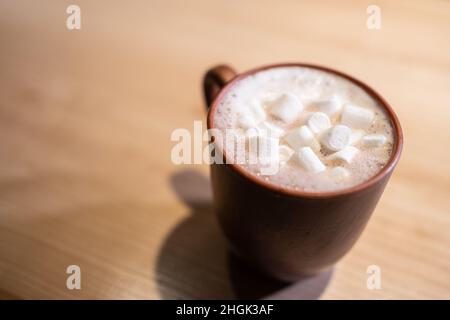 tazza con cioccolata calda, cioccolata, cioccolata, cioccolata calda e marmellata dolce su un tavolo di legno Foto Stock