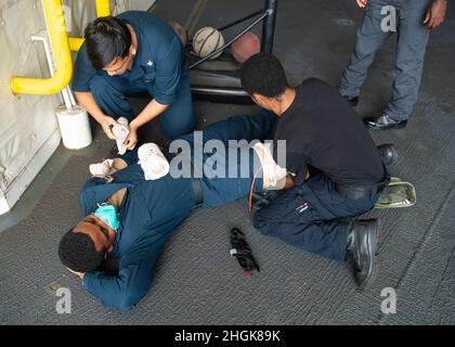 210830-N-LK667-0008 OCEANO ATLANTICO (AGOSTO 30, 2021) Specialista culinario 3a classe Angel A. Sandoval, left, e Seaman Apprentice Kyonte C. Washington, Right, Treat Aviation Boatswain's Mate (Airman Handling) Airman Antoine N. Harris' lesioni simulate durante un trivello di addestramento di massa a bordo della base del mare di Expeditionary USS Hershel 'Woody' Williams (ESB 4), 30 agosto 2021. Hershel 'Woody' Williams è in fase di dispiegamento programmato nell'area della Sixth Fleet degli Stati Uniti di operazioni a sostegno degli interessi e della sicurezza nazionali degli Stati Uniti in Europa e Africa. Foto Stock