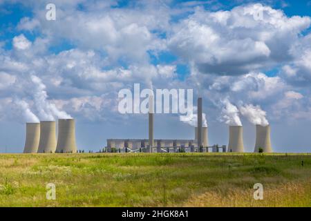Centrale elettrica a carbone in Sudafrica con fumo e vapore che si innalzano dalle pile di fumo e dalle torri di raffreddamento Foto Stock