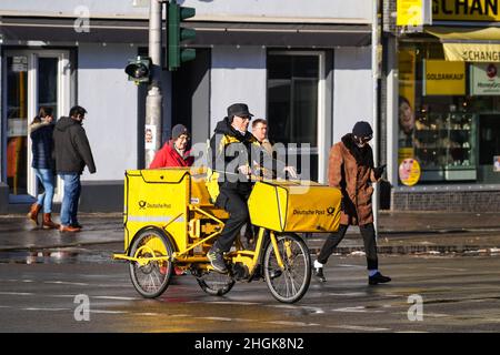 Berlino, Germania. 21st Jan 2022. Un postino corre una bicicletta su una strada a Berlino, in Germania, il 21 gennaio 2022. L'incidenza di sette giorni di COVID-19 in Germania ha continuato ad aumentare e ha superato 700 per la prima volta dall'inizio della pandemia, il Robert Koch Institute (RKI) per le malattie infettive ha detto venerdì. Credit: Stefan Zeitz/Xinhua/Alamy Live News Foto Stock