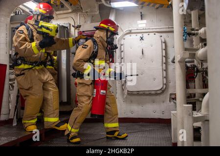 OCEANO PACIFICO (31 agosto 2021) — i marinai entrano nella sala macchine principale durante una trivella antincendio a bordo della nave portuale per il trasporto anfibio USS Portland (LPD 27), 31 agosto. Portland, parte del gruppo USS Essex Amphibious Ready (ARG), insieme all'unità Marine Expeditionary Unit (MEU) del 11th, Opera nell'area di responsabilità della flotta USA 7th per migliorare l'interoperabilità con alleati e partner e funge da pronta forza di risposta per difendere la pace e la stabilità nella regione Indo-Pacific. Foto Stock