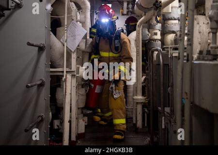 OCEANO PACIFICO (31 agosto 2021) — i marinai si spostano attraverso la sala principale del motore durante una trivella antincendio a bordo di una nave portuale di trasporto anfibio USS Portland (LPD 27), agosto 31. Portland, parte del gruppo USS Essex Amphibious Ready (ARG), insieme all'unità Marine Expeditionary Unit (MEU) del 11th, Opera nell'area di responsabilità della flotta USA 7th per migliorare l'interoperabilità con alleati e partner e funge da pronta forza di risposta per difendere la pace e la stabilità nella regione Indo-Pacific. Foto Stock