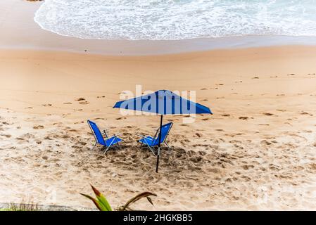 Ombrellone blu sulla spiaggia di Paciencia nel quartiere Rio Vermelho a Salvador, Bahia, Brasile. Foto Stock