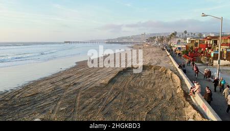 Vista aerea lungo la passerella mentre la folla si riunisce per guardare il tramonto dorato, in bicicletta, jogging, o a piedi a Pacific Beach a San Diego, California, Stati Uniti Foto Stock