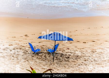 Ombrellone blu sulla spiaggia di Paciencia nel quartiere Rio Vermelho a Salvador, Bahia, Brasile. Foto Stock