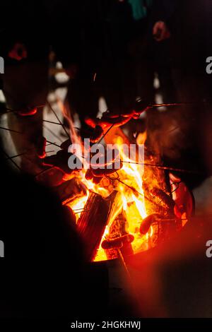 arrostire le salsicce al fuoco in inverno Foto Stock