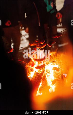 arrostire le salsicce al fuoco in inverno Foto Stock