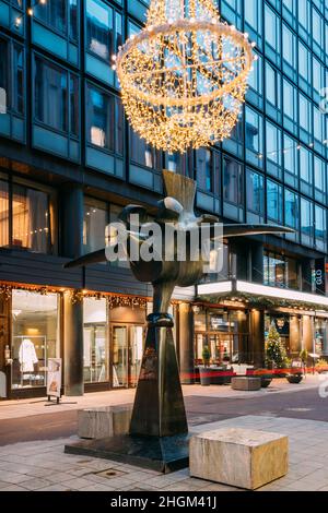 Helsinki, Finlandia. Monumento al dolciario finlandese Karl Fazer, fondatore della famosa pasticceria Fazer in via Kluuvikatu in illuminazione serale Foto Stock