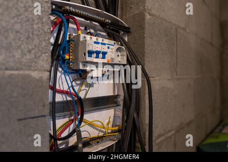 Riparazione del gruppo di comando elettrico. Un elettricista sostituisce i vecchi dispositivi di cablaggio elettrico Foto Stock