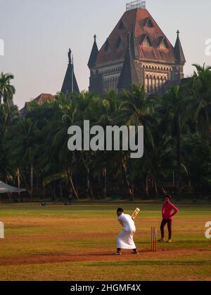 MUMBAI, INDIA - 26 novembre 2021 : uomo musulmano non identificato che gioca il cricket con la sfera di tennis al campo ovale vicino al campo alto di Mumbai Foto Stock