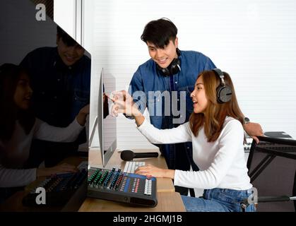 Il tecnico del suono e il produttore di musica controllano la correttezza del registratore audio. Un riflesso della coppia sullo schermo del monitor del computer. Musicisti p Foto Stock