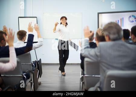 Gli studenti alzando le mani per fare domanda durante il seminario Foto Stock