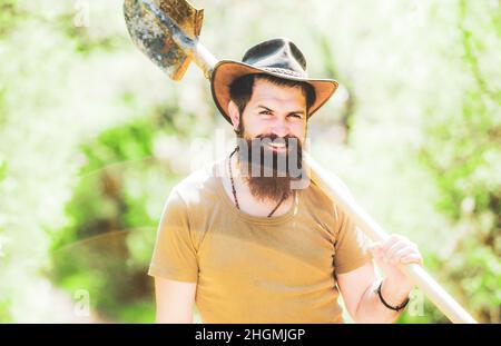 Agricoltura di lavoro felice. Uomo anziano giardinaggio in giardino. Coltivatore che lavora su campo. Concetto di produzione di alimenti biologici. Foto Stock