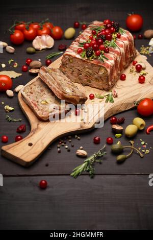 Tradizionale terrina francese coperta con pancetta su sfondo di legno scuro Foto Stock