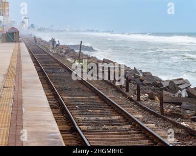 Piattaforma e il mare alla stazione ferroviaria di Kollupiitiya a Colombo, Sri Lanka. La stazione è una delle più trafficate della ferrovia costiera l Foto Stock