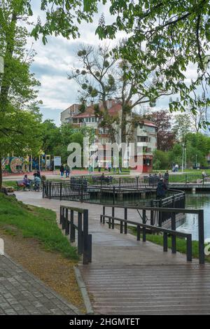 Kaliningrad, Russia - 16 maggio 2021: Parco giochi vicino stagno con famiglie e persone rilassanti Foto Stock