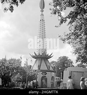 Il popolare ‘Festival Chocolate Shop’ al Festival of Britain Pleasure Gardens, Battersea Park, Londra, Inghilterra, Regno Unito durante le celebrazioni del 1951. I giardini di piacere erano una parte importante del festival. Un design molto decorativo e divertente è una caratteristica del negozio con motivi biologici ‘vegetali’ utilizzati – un ‘ananas’ al di fuori dell'edificio. È inoltre coperto da lampadine per l'illuminazione notturna. Questa immagine proviene da un vecchio negativo amatoriale in bianco e nero – una fotografia d'epoca del 1950s. Foto Stock