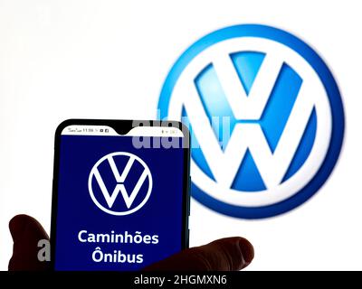In questa illustrazione della foto, il logo Volkswagen Caminhoes e Onibus viene visualizzato sullo schermo di uno smartphone con il logo Volkswagen AG sullo sfondo. Foto Stock