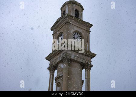 I fiocchi di neve si snoda oltre la torre dell'orologio nella baia di Herne mentre una doccia pesante della neve arriva dal mare nel febbraio 2021. Foto Stock