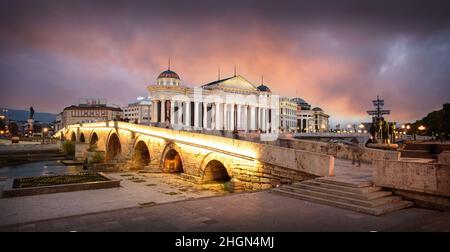 Skopje, Repubblica della Macedonia del Nord. Il Museo Archeologico di Macedonia e il Ponte delle civiltà al tramonto. Foto Stock