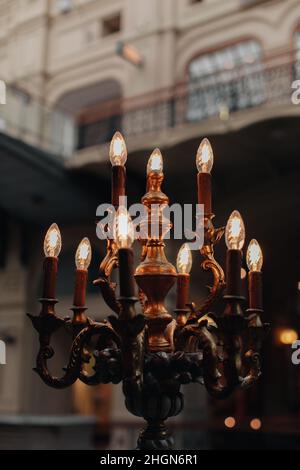 Lampade in bronzo d'epoca che bruciano candele in un interno classico Foto Stock