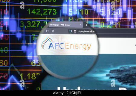 AFC Energy Company logo su un sito web con blurry mercato azionario sviluppi in background, visto su uno schermo di computer attraverso una lente d'ingrandimento. Foto Stock