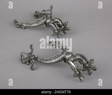 Coppia di Rowel Spurs prima metà 17th secolo Tedesco del Sud questo paio di spuri molto ornamentali è cesellato e trafitto con motivi geometrici, e ogni oggetto presenta tre righe forate a forma di fiore. Alcuni tipi di contrafforti con diverse righe sono stati talvolta utilizzati nel 17th secolo con cavalli particolarmente difficili. Tuttavia, su questa coppia sembra essere più una caratteristica ornamentale di lusso, per un paio indossato come un pezzo di gioielleria, che un miglioramento veramente equestre. Per esempio, la remi esterna di ogni sperone è senza funzione poiché non toccherebbe mai il fianco del cavallo. Tali spur sono note Foto Stock