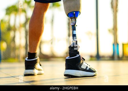 atleta disabili con protesiche passeggiate in spiaggia all'aperto al tramonto Foto Stock