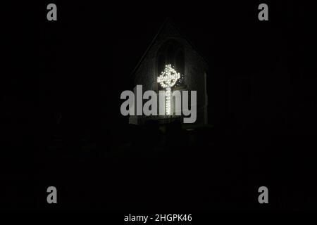 Croce celtica nelle luci alla chiesa di San Pietro, Coverack, Cornovaglia. Parte del display annuale delle luci di Natale. Foto Stock