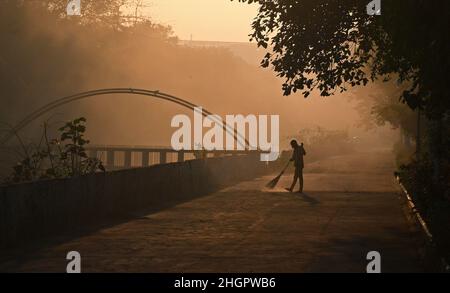 Una spazzatrice pulisce una strada al mattino presto a Mumbai. Foto Stock