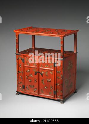 Cabinet con progettazione di farfalle 18th secolo Giappone (Ry?ky? Isole) Farfalle e fiori si trovano spesso nelle arti visive della Cina e del Ry?ky? Isole nel XVIII secolo. Le farfalle che decorano questo mobile sono state dipinte in lacca nera e oro e intarsiate con guscio di perla. La forma complessiva del gabinetto e i quattro piedi piccoli mostrano paralleli all'arte giapponese. Una grande apertura a forma di swastika nella parete posteriore del gabinetto suggerisce che una volta era usata per ospitare sutra buddisti o paraphernalia religiosa. Armadio con progettazione di farfalle. Giappone (Ry?ky? Isole). Foto Stock