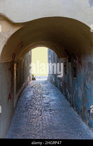 Vecchio passaggio di casa con intonaci shabby che porta alla luce nella città di Tulln, Austria Foto Stock