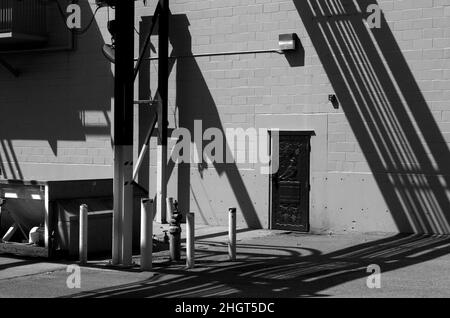 Immagine in bianco e nero di ombre e linee geometriche sullo sfondo dell'edificio Foto Stock