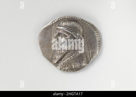 Drachm argento ca. 121–91 a.C. i Numismatici partigiani – gli studiosi che studiano le monete – si riferiscono al lato anteriore della moneta, che di solito presenta come il capo di una persona o di un dio, il «obverso» E il lato posteriore come il “rovescio”. Sull’ossale di questa moneta d’argento, un busto del re si affaccia a sinistra. Ha capelli ondulati che terminano con ricci e una barba lunga, e indossa un diadem (la fascia indossata dagli atleti vittoriosi dell'antica Grecia) sulla sua testa. Un bordo di punti circonda l'immagine. Il retro mostra un uomo seduto rivolto verso destra. Indossa maniche e pantaloni sotto un mantello, nonché un appuntito Foto Stock