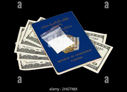 Pacchetto con droga sul passaporto afghano e dollari americani su sfondo nero Foto Stock