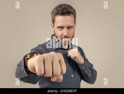 L'uomo maturo si trova in posizione di combattimento offensiva con fuoco selettivo pugno clenched, potere Foto Stock