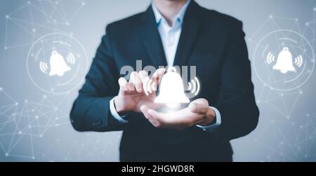 Uomo d'affari, toccare il dito per premere il pulsante. Pulsante del campanello di notifica sul primo piano dello schermo dell'app per smartphone, notifica dell'app sullo schermo dello smartphone, Remot Foto Stock