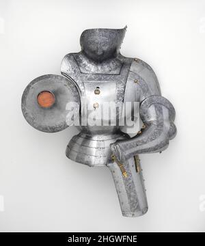 Mezza armatura ca. 1510–20 e successivi elmetto e pezzi di rinforzo attribuiti a Kolman Helmschmid tedesco il disegno delle armature è stato spesso influenzato dallo stile degli indumenti maschili. Da circa 1510 a circa 1530, nella Germania meridionale e in Austria, questa tendenza è stata portata ad un estremo in elaborata armatura che direttamente imitato fiammeggiante puffed e slashed costume. Solo gli armatori più abili e fantasiosi potrebbero ricreare con successo velluto tagliato e seta ricamata in acciaio martellato e inciso. I più rinomati praticanti di questo stile esigente furono Conrad Seusenhofer (attivo dal 1500 al 1517) di Innsbr Foto Stock