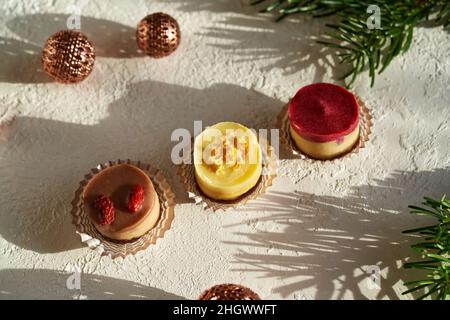 Biscotti di Natale vegani crudi al mirtillo, lampone, limone, goji e banana con rami di abete Foto Stock