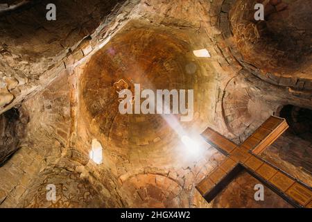 Mtskheta Georgia. Vista dal basso della Grande Croce di legno sulle pareti di pietra e sfondo della cupola della Chiesa di Jvari Foto Stock