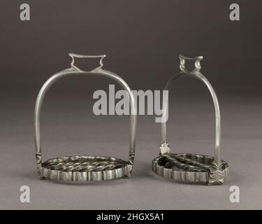 Coppia di staffe per bambini fine 17th-18th secolo tedesco o spagnolo le piccole dimensioni di queste staffe significa che sono stati probabilmente fatti per un bambino. I bambini di famiglie benestanti inizierebbero le lezioni di equitazione non appena potrebbero sedersi su un pony, solitamente intorno all'età di 3. L'equitazione era una componente importante della nobile società europea, e i bambini dell'élite si aspettavano di padroneggiare l'arte dell'equitazione. Inoltre, come molti nobili servivano nella cavalleria, era essenziale per loro essere abili cavalieri nel momento in cui erano abbastanza vecchi per andare in guerra. Coppia di staffe per bambini. Tedesco o spagnolo. l Foto Stock