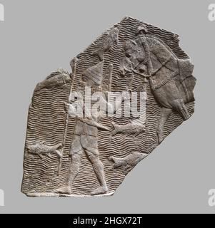 Relief fragment: cavalryman leading his horse beside a stream ca. 704–681 B.C. Assyrian This relief fragment dates to the time of the Assyrian king Sennacherib (r. 704-681 B.C.), and comes from the great Southwest Palace, called by Sennacherib the 'Palace Without Rival,' at Nineveh in northern Iraq. It shows an Assyrian soldier leading a horse beside a large river, and comes originally from a much larger scene depicting an Assyrian campaign that filled a room of the palace.The soldier is equipped in typical Assyrian fashion with a high conical helmet, a short spear, a bow (seen with quiver on Stock Photo
