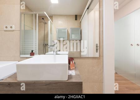 Bagno con lavandino in porcellana bianca con specchio quadrato senza cornice e saponetta in marmo Foto Stock