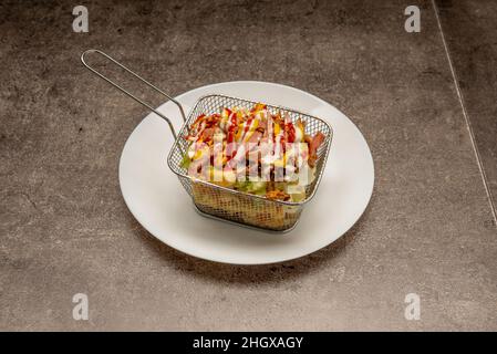 Le patate pazze sono una specie di fast food che consiste di patatine fritte di ogni tipo ed è accompagnato da senape, peperoncino, origano Foto Stock