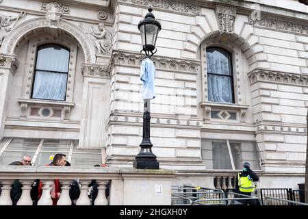 Un pezzo di uniforme NHS appeso su un lampione durante la dimostrazione. Entro il 2022 aprile, 100k membri del NHS dovranno essere vaccinati completamente o perdere il loro posto di lavoro. Alla luce di questo requisito draconiano, gli infermieri NHS si sono riuniti per protestare contro tale coercizione, difendendo la loro libertà medica e accusando il governo per un maltrattamento totale degli operatori sanitari per la pandemia. Altri gruppi anti-blocco e anti-vaccino hanno protestato congiuntamente contro le restrizioni imposte dal governo, e minacciano di scendere in strada se le restrizioni non saranno revocate entro il 27th gennaio 2022. Foto Stock