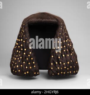 Wig anelli di Sithathoryunet, su una moderna parrucca ca. 1887–1813 a.C. Regno di mezzo due scatole nella nicchia dei gioielli della tomba di Sithathoryunet sembrano aver tenuto le sue parrucche cerimoniali. Le scatole di legno e i capelli si erano completamente decomposti, ma 1.251 anelli d'oro in due misure che avevano decorato una delle parrucche sono stati conservati. Sono stati collocati su una moderna parrucca in un accordo suggerito da una testa di legno che il Metropolitan Museum ha scavato a Lisht, un altro cimitero reale del Regno di Medio. Una corona d'oro e un pettorale con il nome di Amenemhat III, entrambi nel Museo Egizio, il Cairo, sono stati imballati nella sa Foto Stock