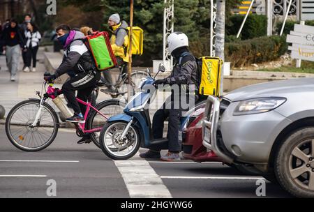 Bucarest, Romania - 03 gennaio 2022: Un corriere Glovo per la consegna di cibo consegna il cibo a Bucarest, Romania. Foto Stock