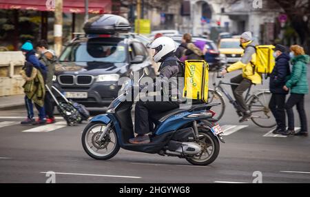 Bucarest, Romania - 03 gennaio 2022: Un corriere Glovo per la consegna di cibo consegna il cibo a Bucarest, Romania. Foto Stock