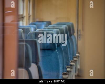Immagine di un tipico posto a sedere da un treno europeo, vuoto, lungo il tragitto sulla linea espressa interurbana AM tipica dall'Europa, in un vecchio treno UEM. Foto Stock
